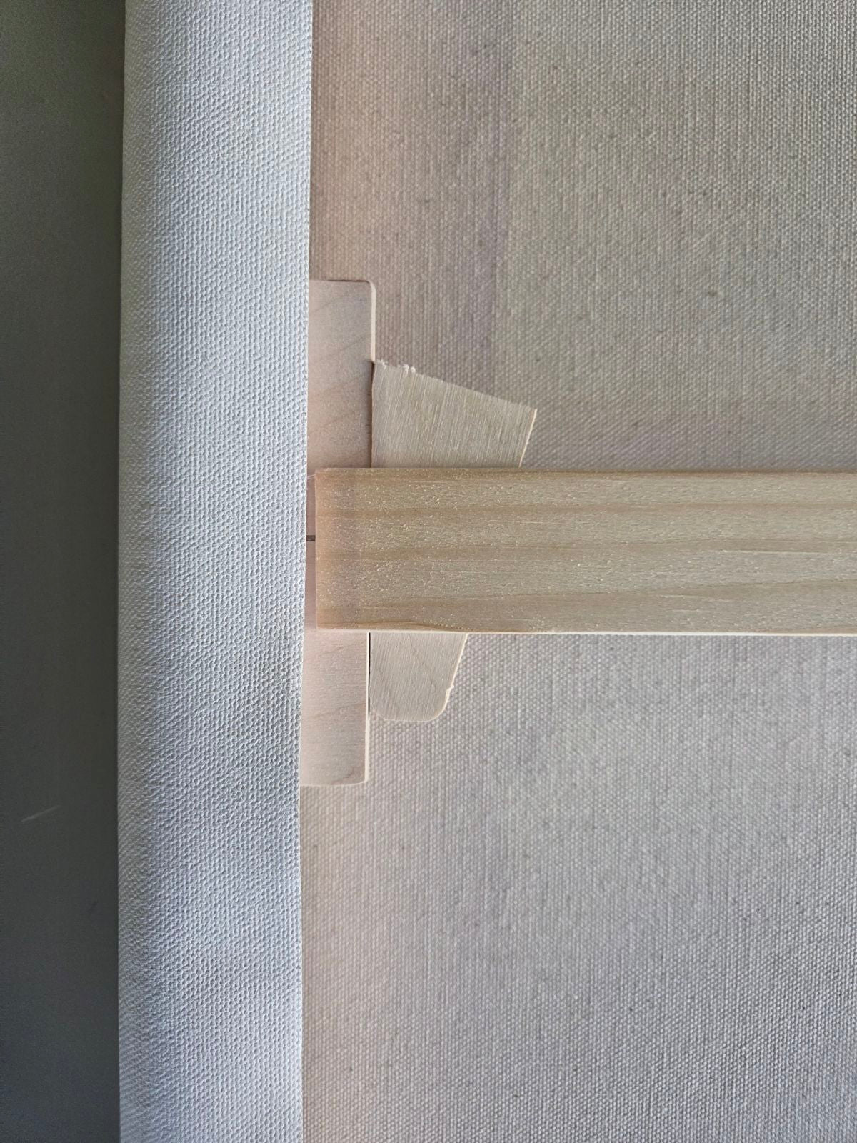 Close-up of a textured wall with a wooden trim detail, tightening wedge